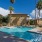 a swimming pool with palm trees and buildings in the background